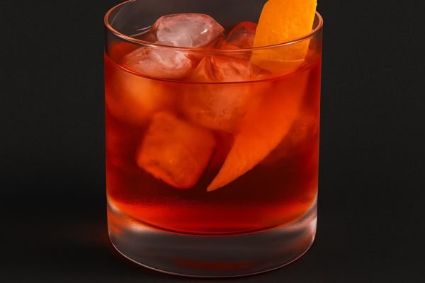 Cocktail Cardinale Elettrico preparato con Tesla Gin, Tesla Vermouth e Tesla Bitter, guarnito con scorza d’arancia.